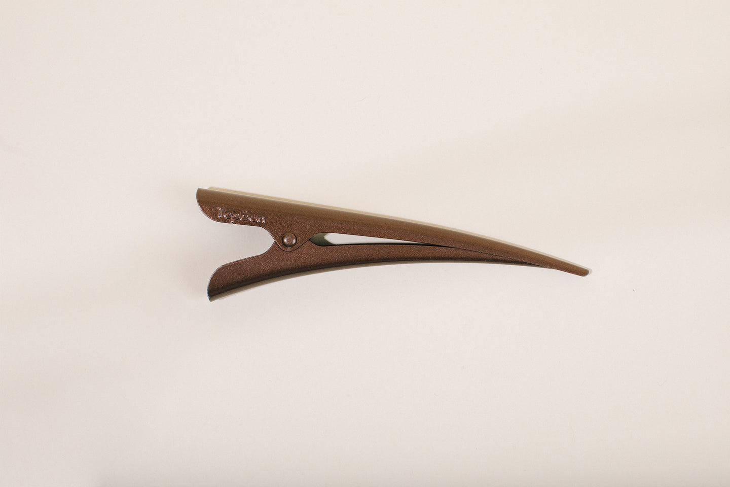 Medium brown TopBun hair clip against neutral background
