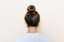 Medium brown TopBun hair clip shown holding a high bun in brunette hair