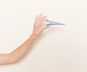 Gray matte TopBun hair clip shown in a hand for size perspective