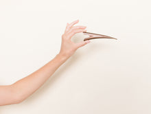 Medium brown TopBun hair clip shown in a hand for size perspective