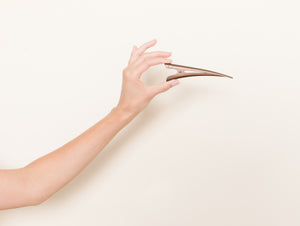 Medium brown TopBun hair clip shown in a hand for size perspective