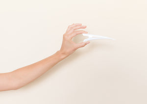 Glossy white TopBun hair clip shown in a hand for size perspective